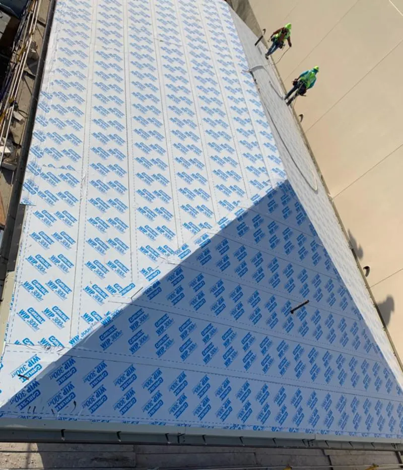 Professional roofers installing underlayment on a metal roof in El Reno